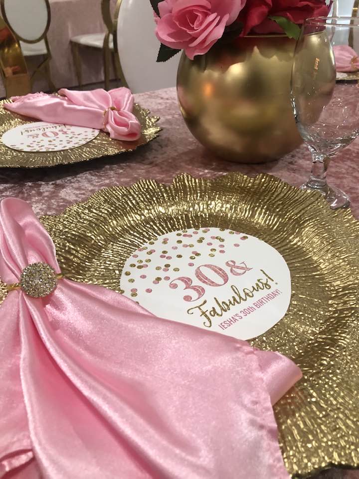 place setting for 30th birthday party. Gold plate reads "30 & Fabulous" with pink satin napkin